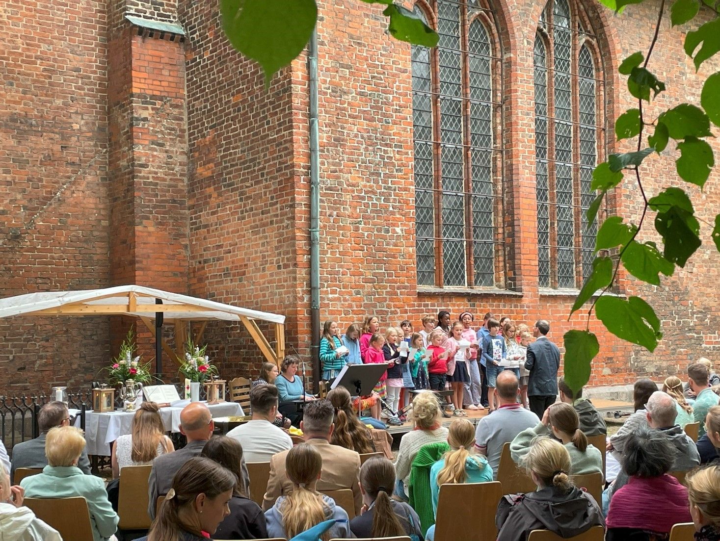 Open-Air-Gottesdienst vor der Aegidienkirche. Die Gäste bestaunen das Konzert des Kinderchores.