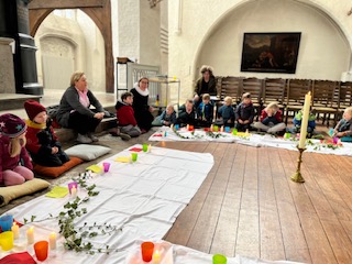 Mehrere Kinder sitzen an einem Tisch mit Bastelutensilien